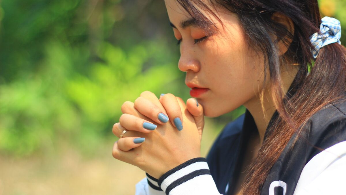 woman praying hands together faith